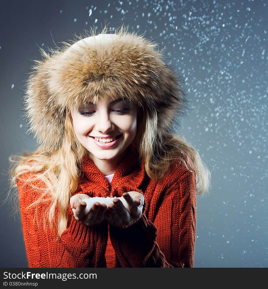 Young beautiful girl rejoices to snow, On a dark blue background