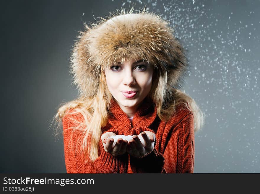 Young beautiful girl rejoices to snow, On a dark blue background