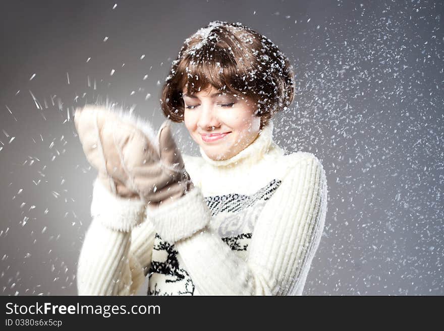 Young beautiful girl rejoices to snow, On a dark blue background