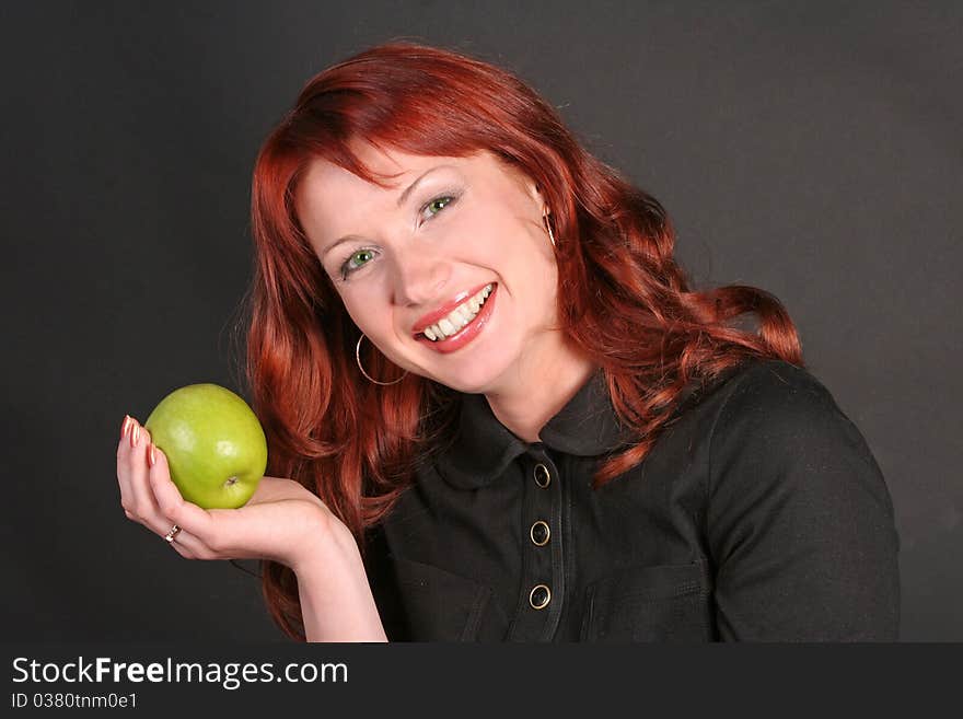 Portrait of happy redheaded beautiful woman with an apple in a studio. Portrait of happy redheaded beautiful woman with an apple in a studio