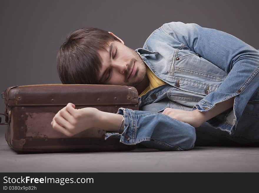 Man sleeping on suitcase waiting for travel