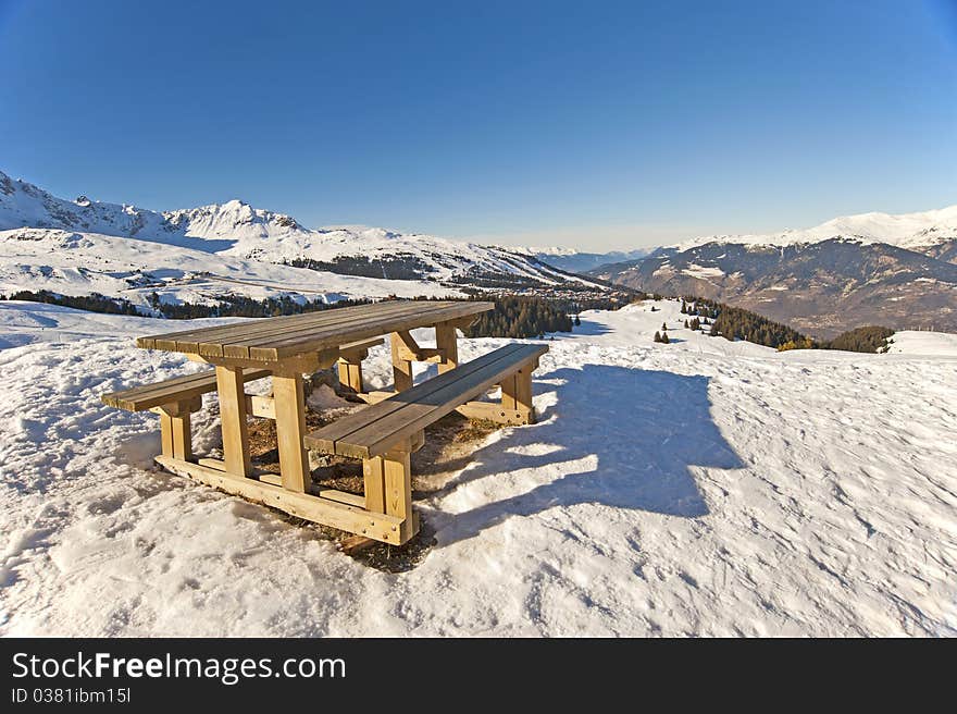 Picnic table on the top of a snowy mountain with a view. Picnic table on the top of a snowy mountain with a view