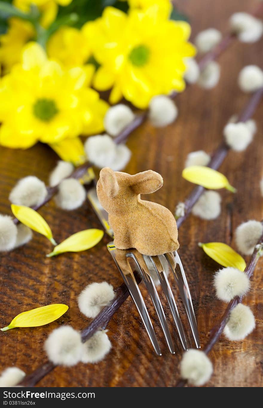 Fork with easter bunny on table with flowers. Fork with easter bunny on table with flowers