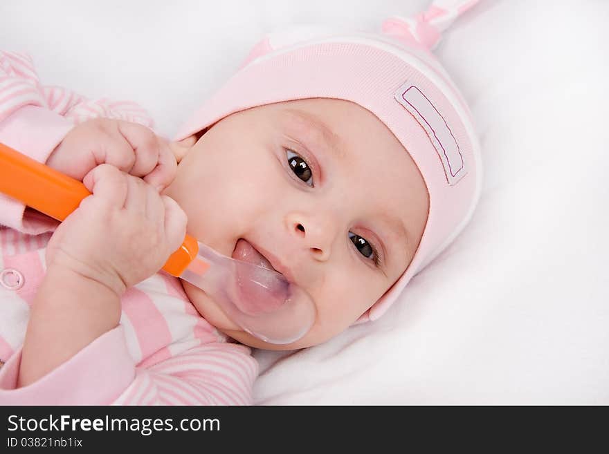 Closeup face of a beautiful newborn girl with spoon