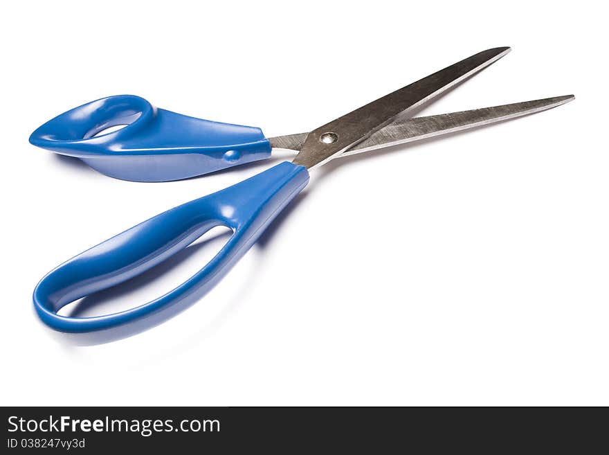 Blue metal scissors over white background. Studio shot.