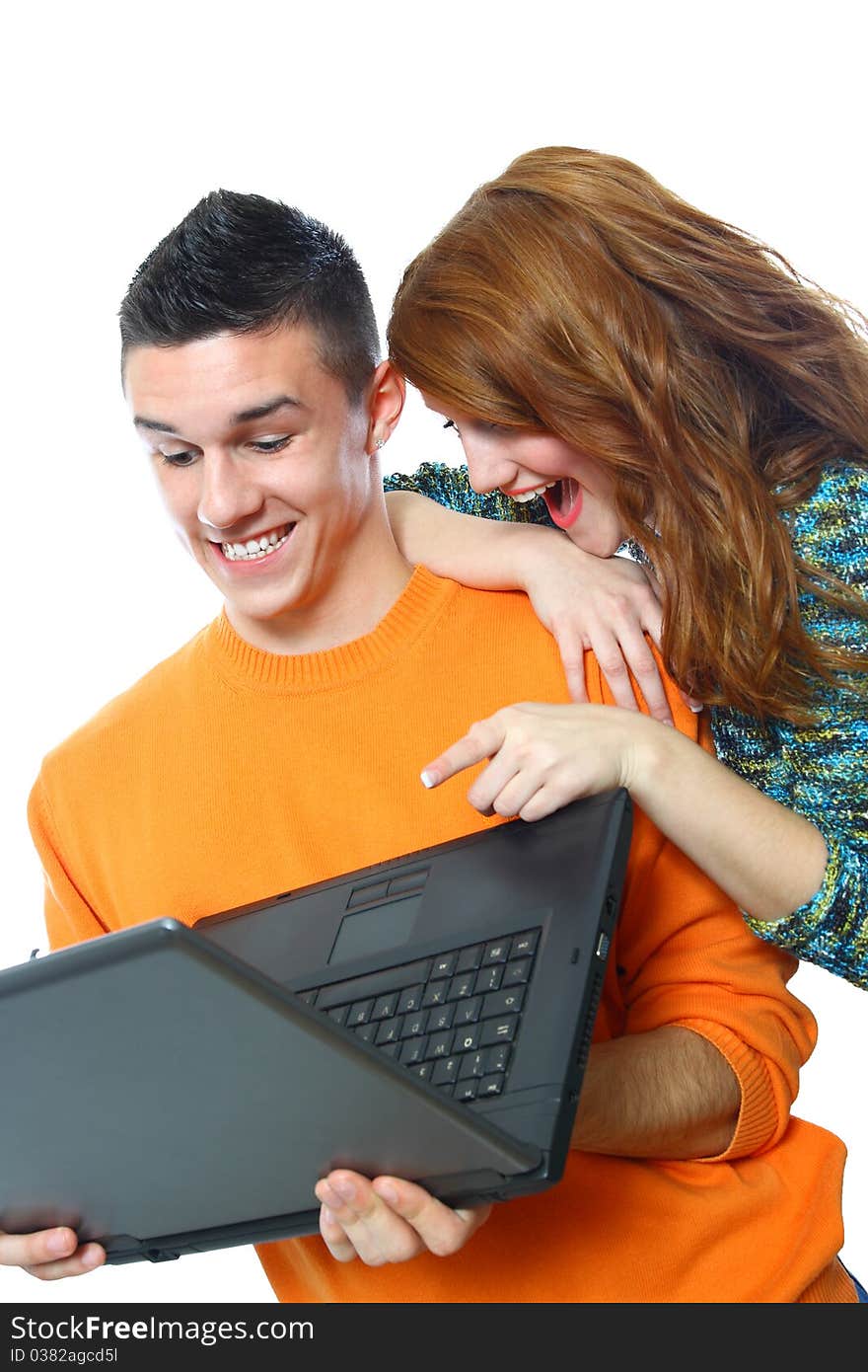 Two smiling teenagers looking at laptop