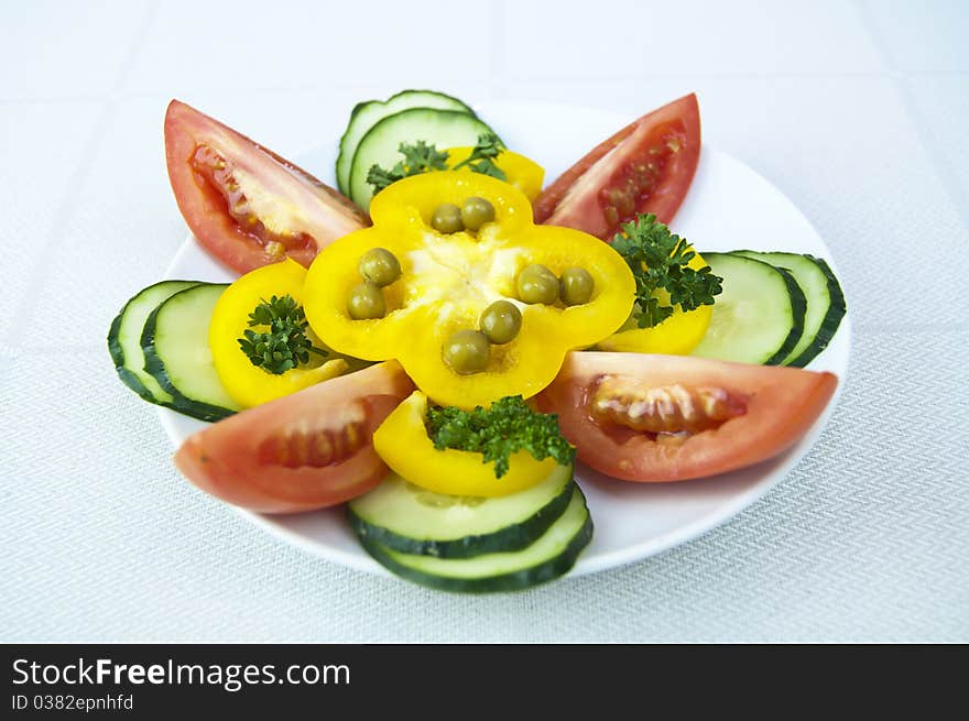 Colored raw vegetables for salad in plate on a table