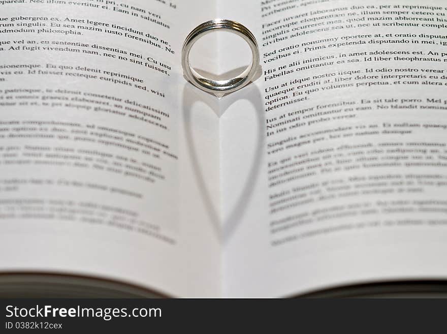 Ring casting heart shadow in book. Ring casting heart shadow in book.