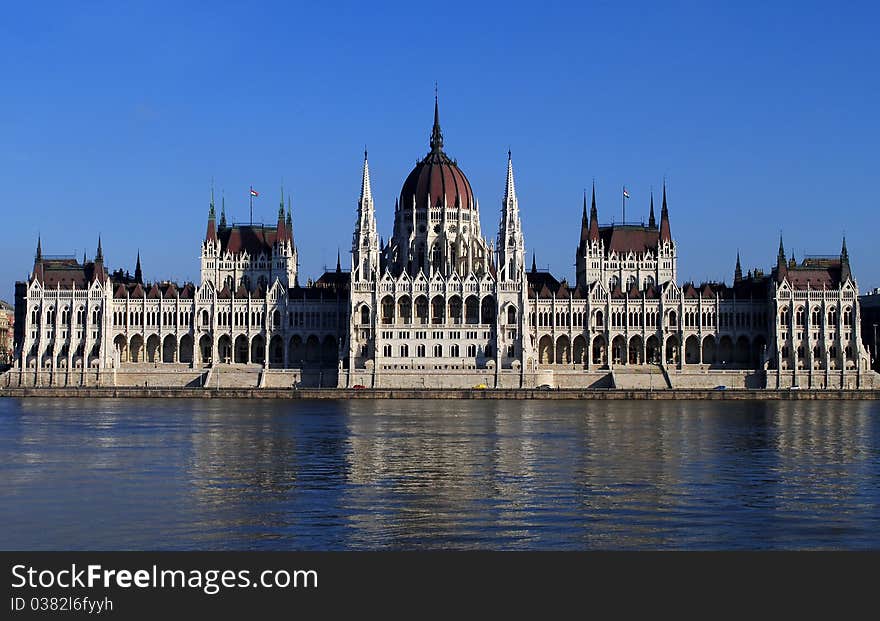 The Hungarian parliament on the bank of Danube Very sunny and bright sky. Reflection on the river. The Hungarian parliament on the bank of Danube Very sunny and bright sky. Reflection on the river.