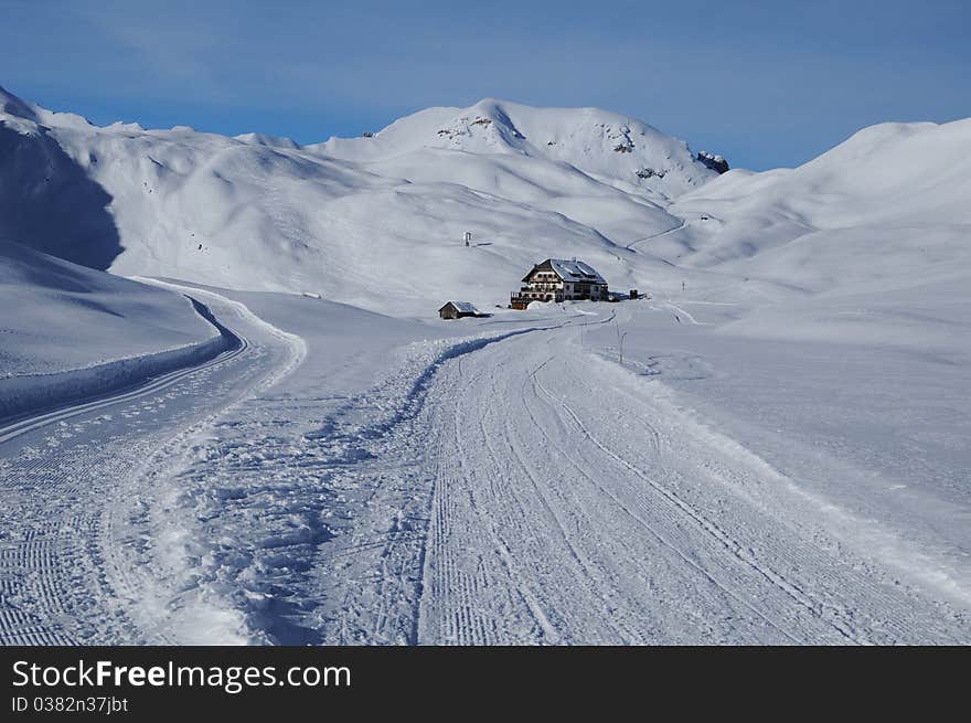 Faraway hut surrounded by snow in the mountains, Dolomites, Italy