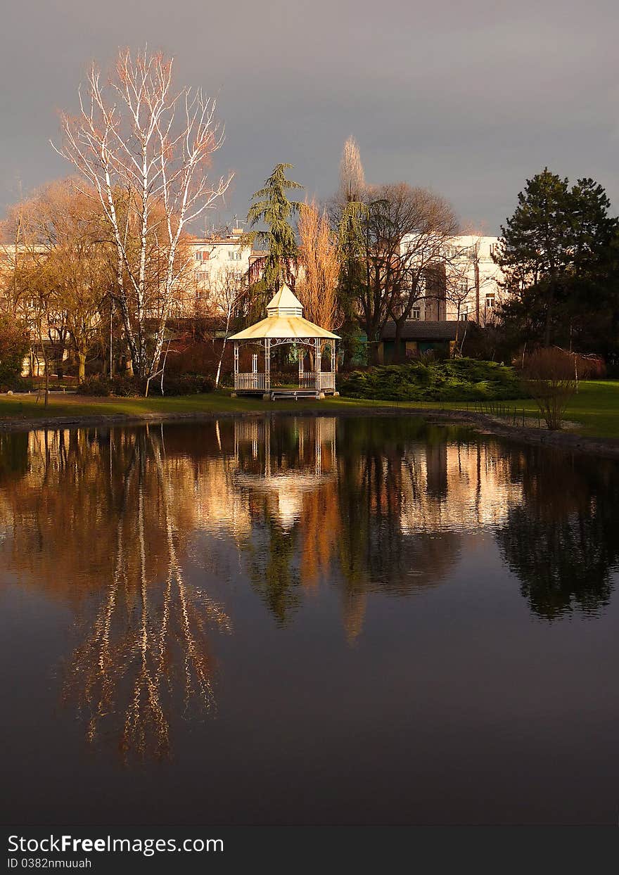 A reflection of a house at a lake shore with a gray winter sky in the background. A reflection of a house at a lake shore with a gray winter sky in the background