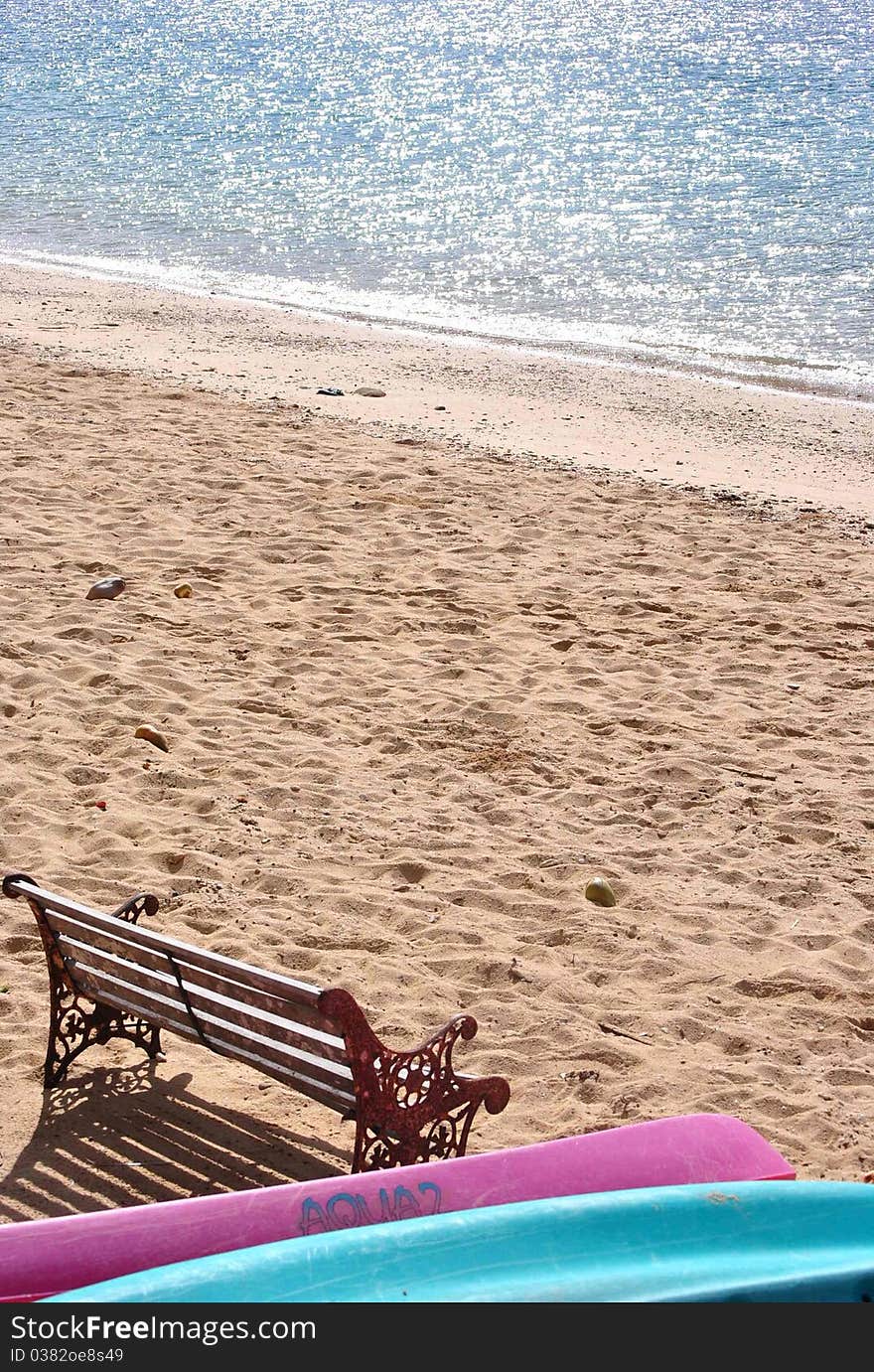 Kayaks and a bench on the beach