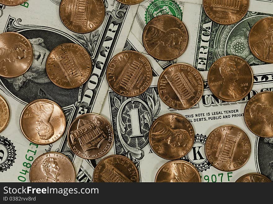 A bunch of pennies covering a bunch of one dollar bills, american currency. A bunch of pennies covering a bunch of one dollar bills, american currency