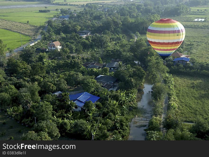 Hot air balloon floating in the sky over land.