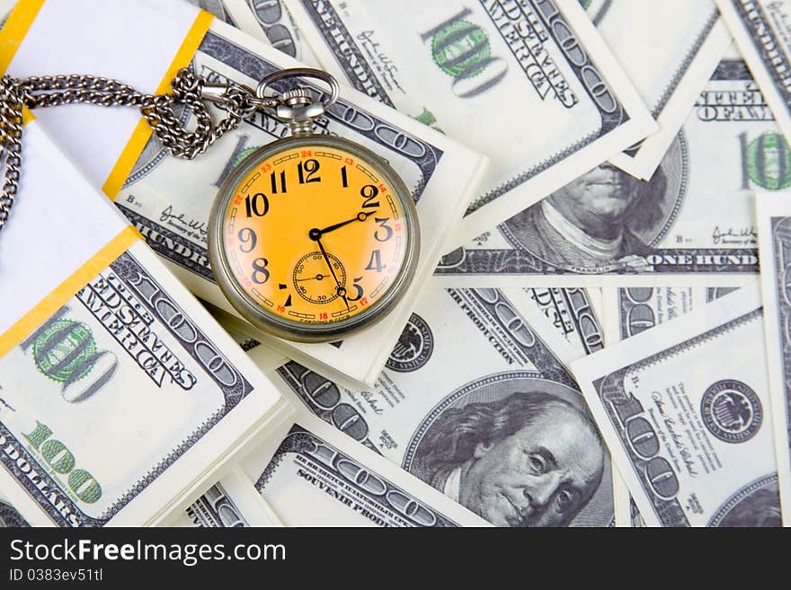 Pocket watch on a stack of dollars, reflecting time and money