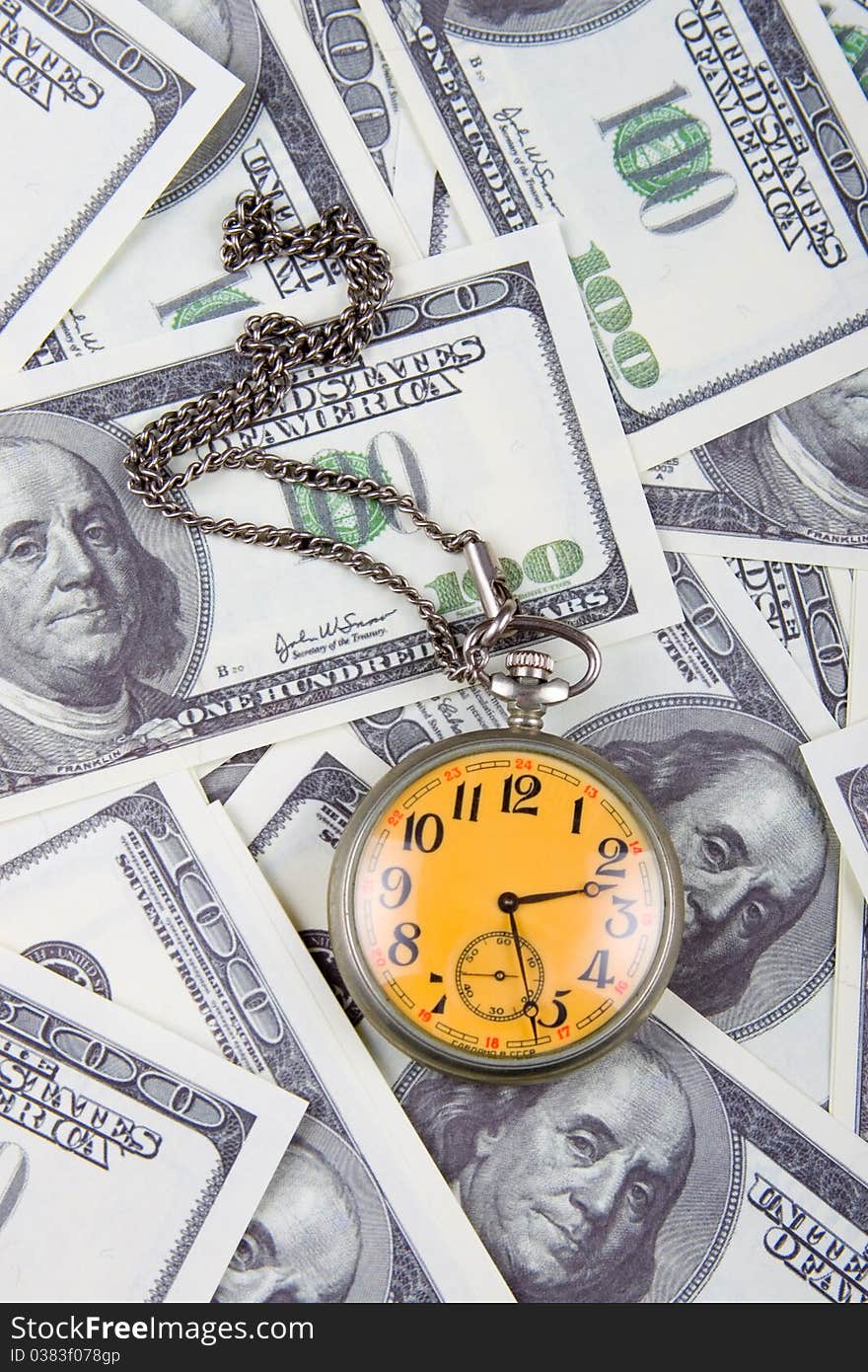 Pocket watch on a stack of dollars