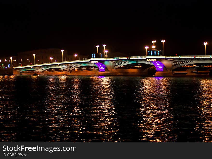 Night bridge in St. Petersburg city with violet illumination