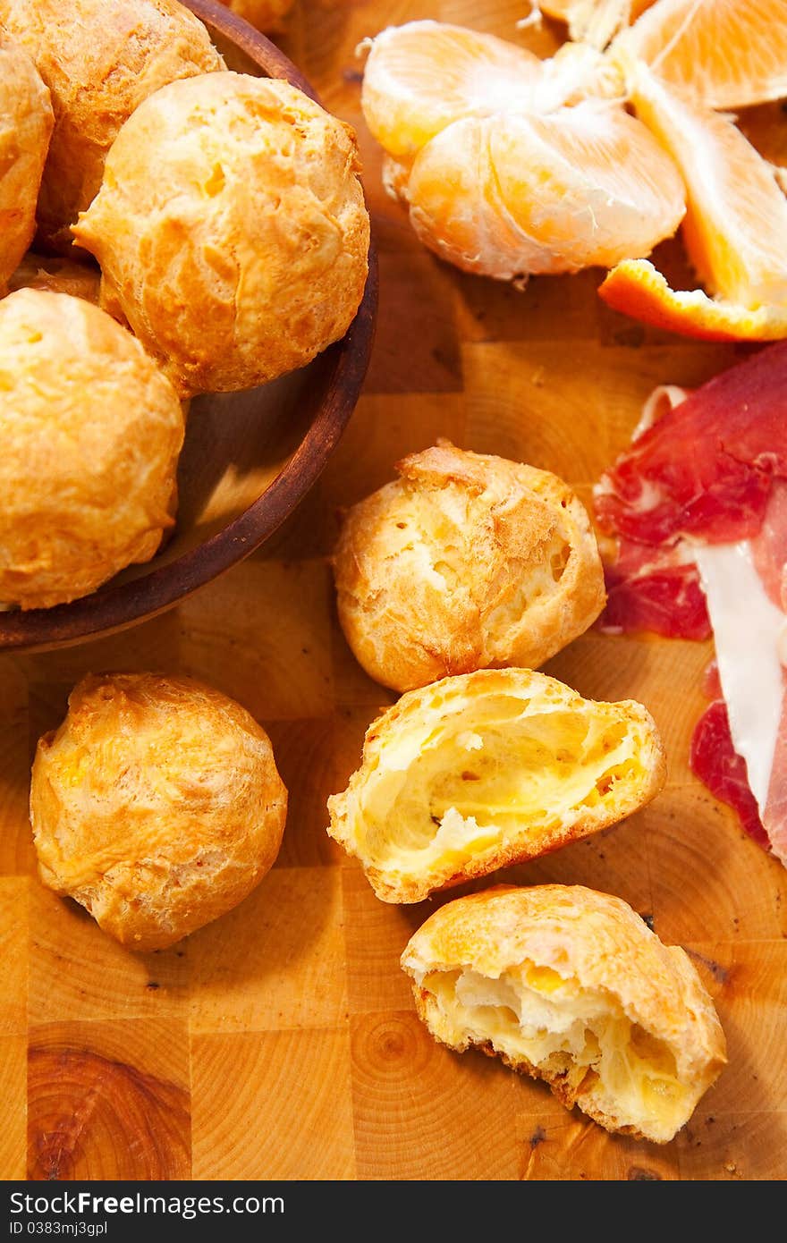 Freshly made cheese gougères on wood cutting board