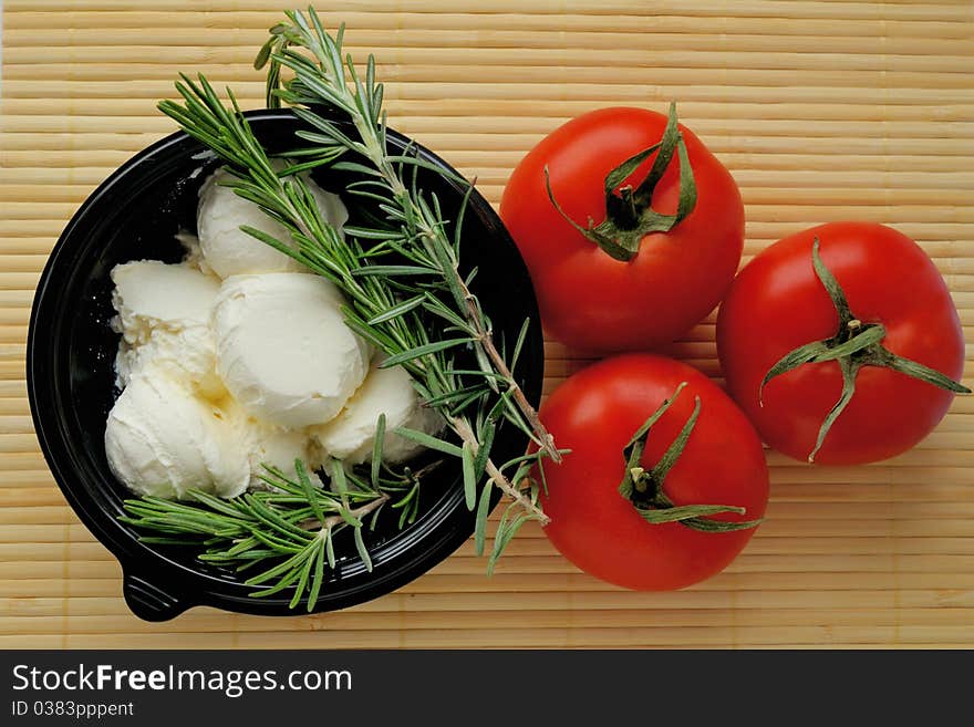 Cream cheese, tomatoes and greens on a bamboo napkin