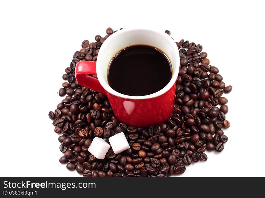 Red mug of coffee with roasted coffee beans and sugar lumps. Red mug of coffee with roasted coffee beans and sugar lumps