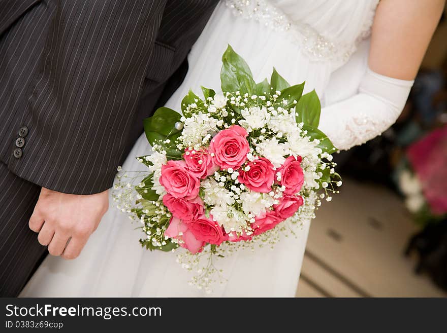 Wedding Bouquet of the bride from pink roses.Gold rings