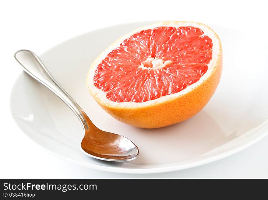 Fresh grapefruit with plate and spoon,