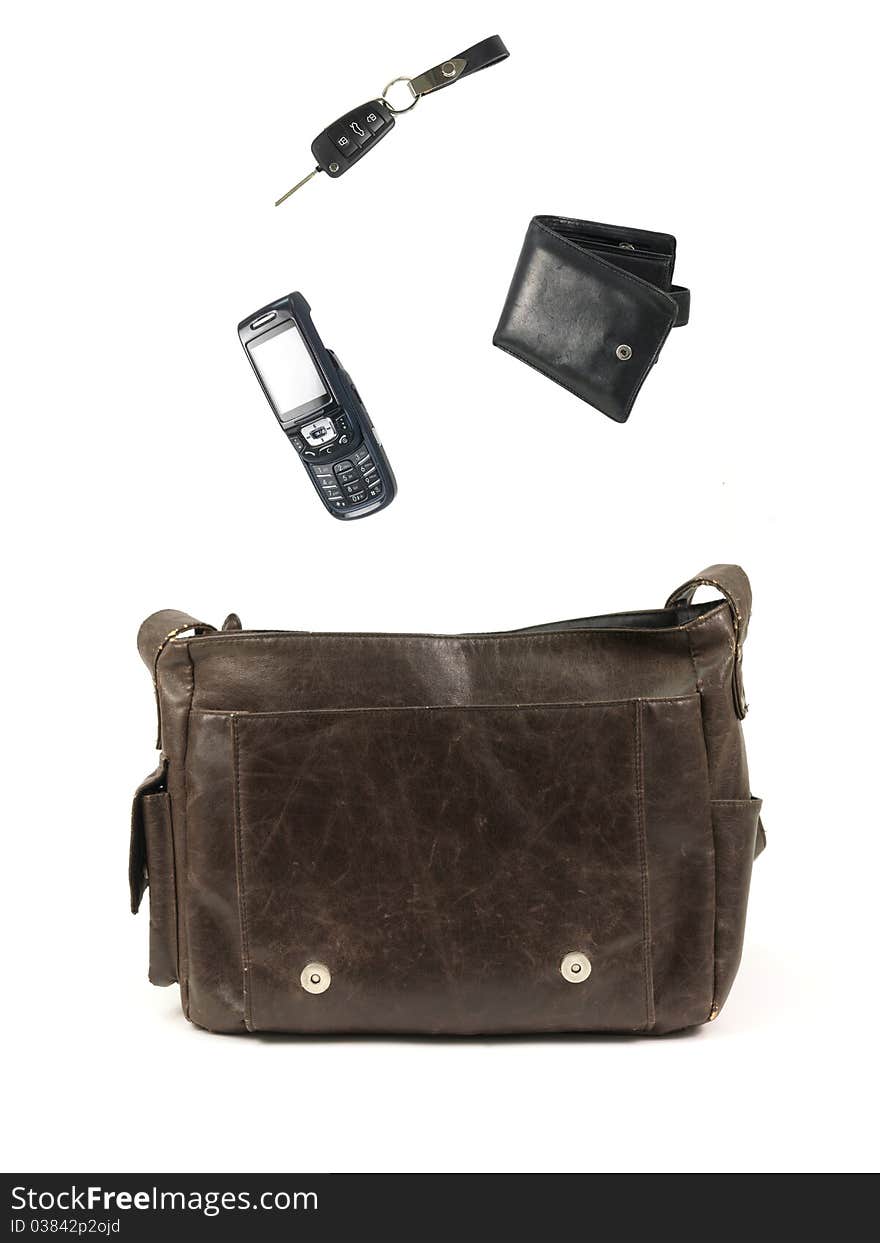 A leather bag and contents isolated against a white background