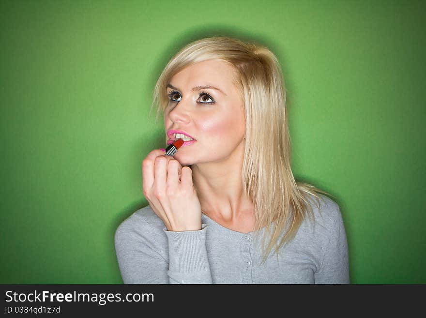 Woman preparing her make-up and hair before the party , on green background. Woman preparing her make-up and hair before the party , on green background