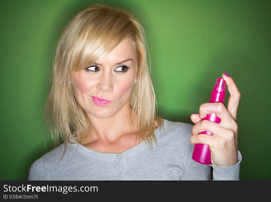 Woman preparing her make-up and hair before the party , on green background. Woman preparing her make-up and hair before the party , on green background