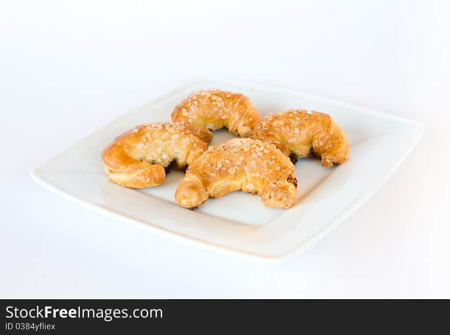 Four fresh golden brown croissants on white plate and isolating background. Four fresh golden brown croissants on white plate and isolating background