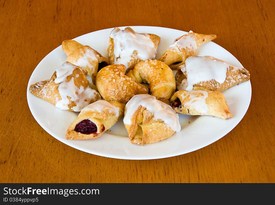 Plate of fresh, golden brown pastry on old wooden table. Plate of fresh, golden brown pastry on old wooden table