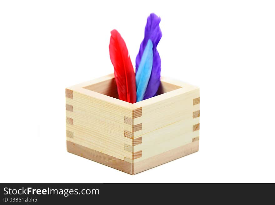 Colorful feathers in a oriental wooden box. Colorful feathers in a oriental wooden box