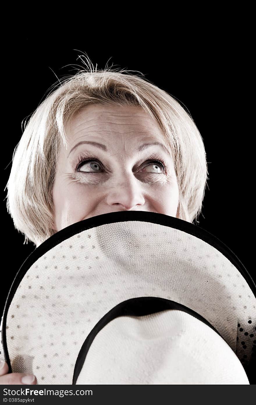 Woman with hat performing on stage, black background. Woman with hat performing on stage, black background