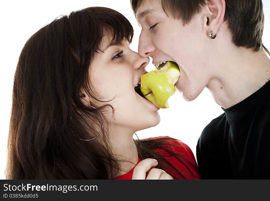 Cheerful young couple eats one green apple