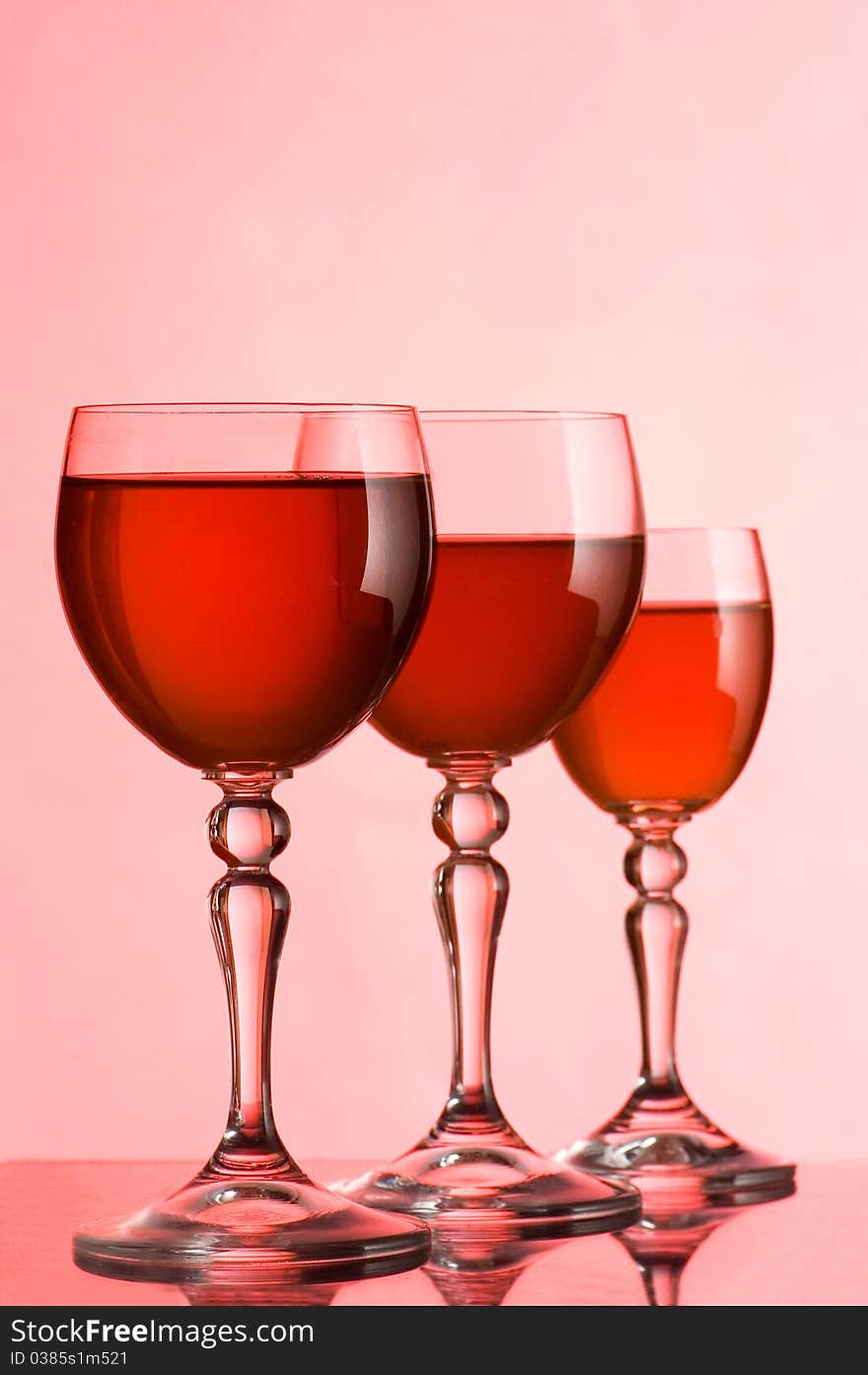 Wine glasses with wine on a pink background