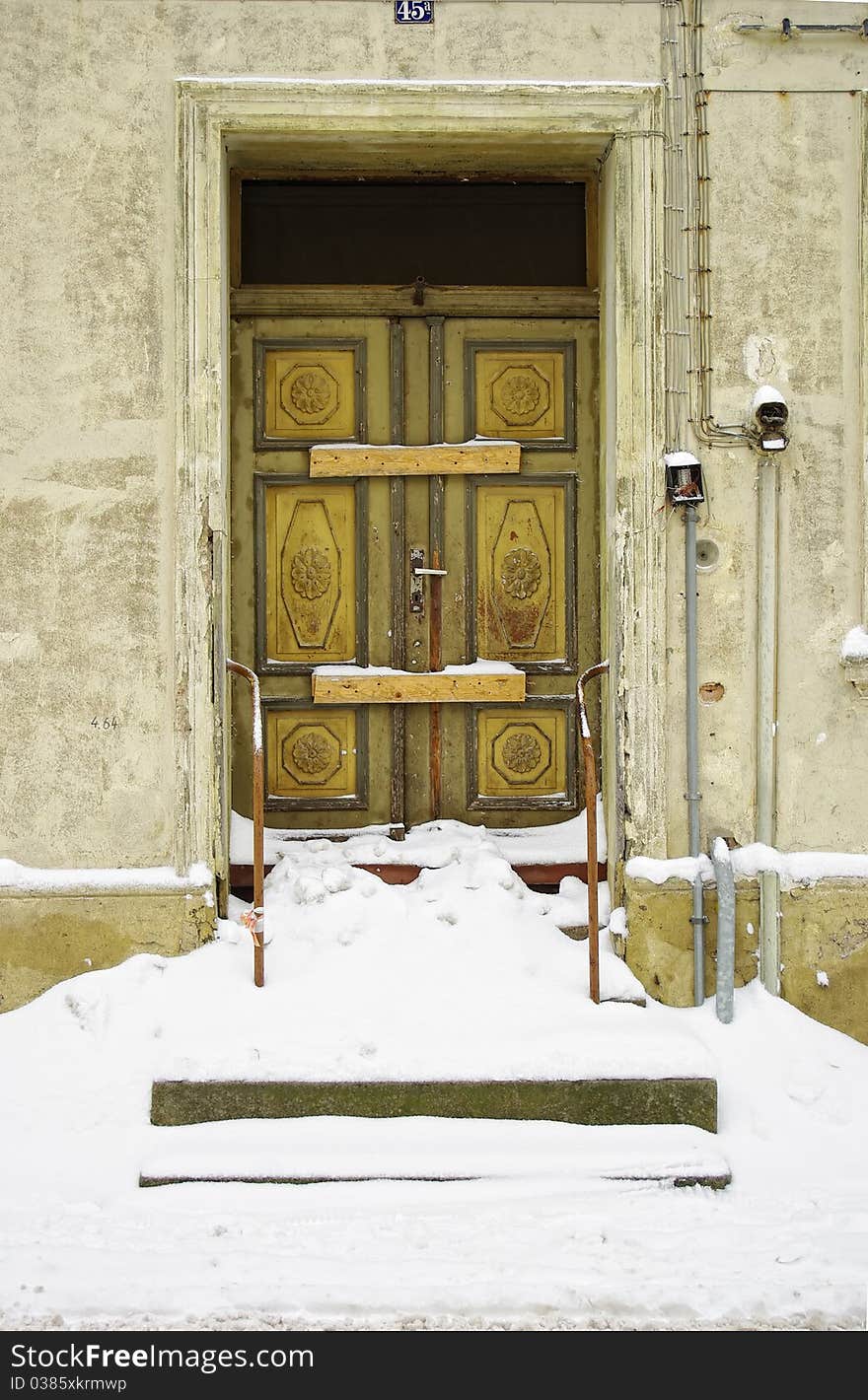 Abandoned old building with snowed in and decayed front door. Abandoned old building with snowed in and decayed front door