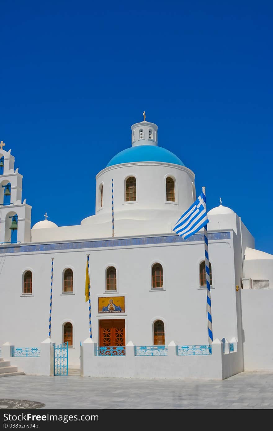 Beautiful white belfry of greek church on island of Santorini in Oia, Greece. And square with greece national flag. Beautiful white belfry of greek church on island of Santorini in Oia, Greece. And square with greece national flag