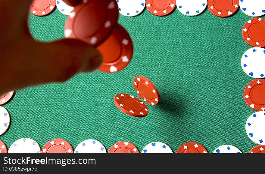 Red gambling chips falling from men hand