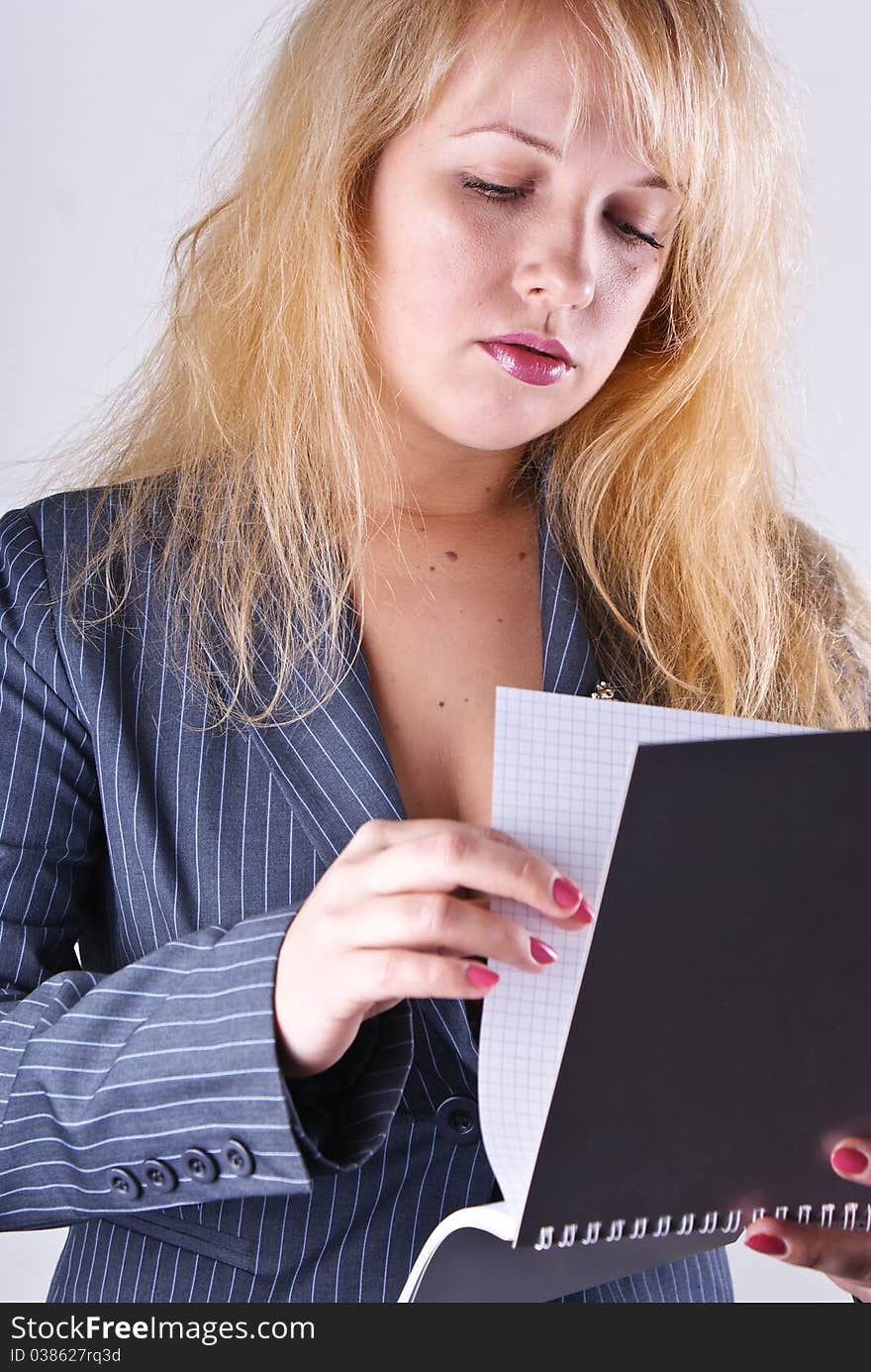 Girl reading a notebook in office