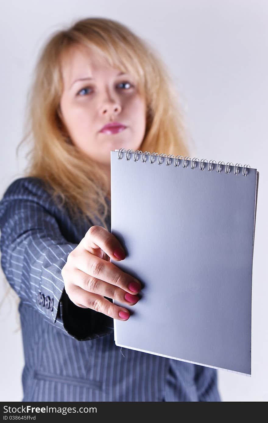 A girl stretches out a notebook on white