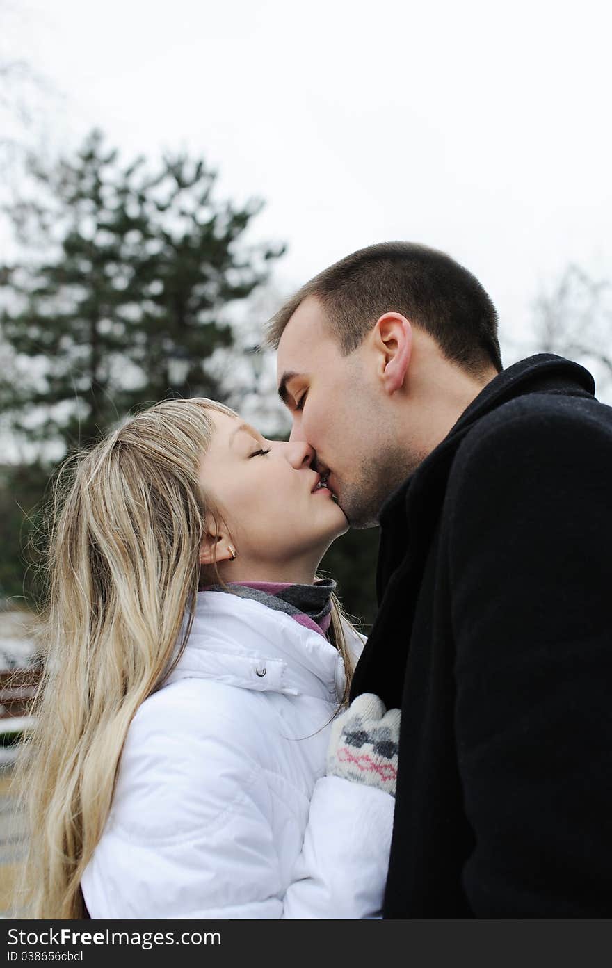 Young love couple kissing each other in a city