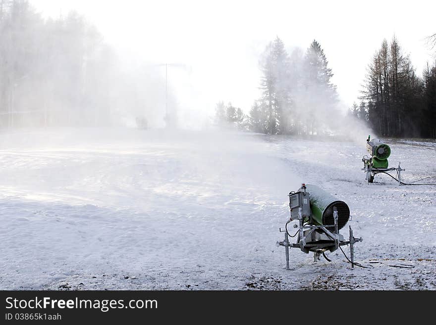 Snow cannons producing artificial snow on ski slopes. Snow cannons producing artificial snow on ski slopes.