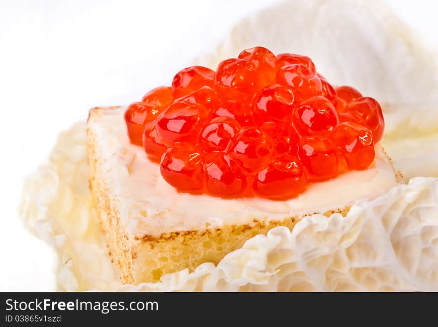 Canape with salmon caviar in a salad list across white