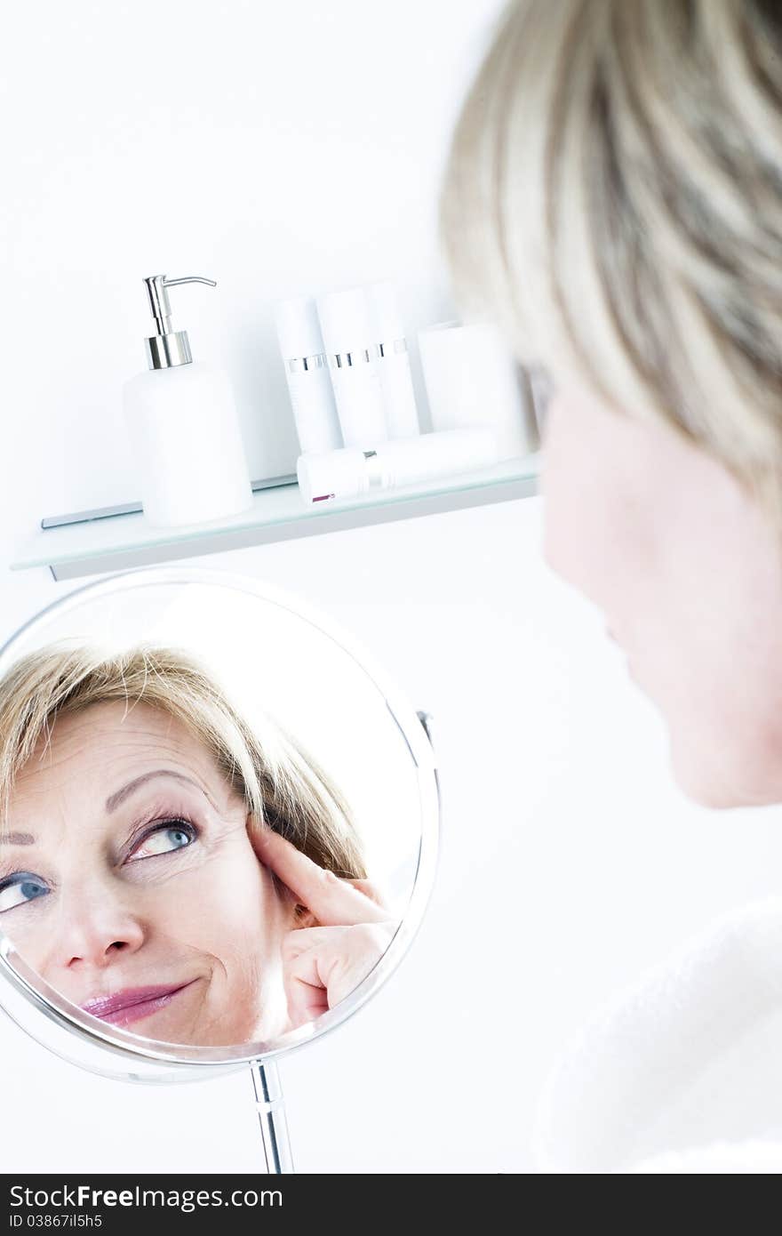 Mature woman looking in the mirror. Mature woman looking in the mirror