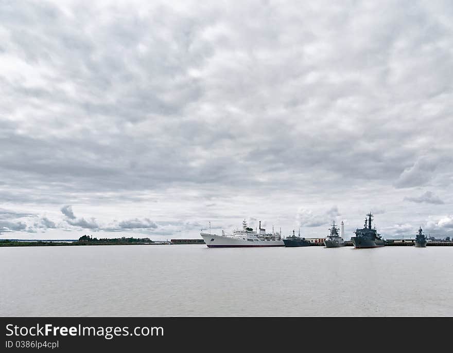 Military and civil ships at the mooring of port Kronstadt. Island Kotlin ( Retusaari by Finnish), Gulf of Finland of Baltic sea. Military and civil ships at the mooring of port Kronstadt. Island Kotlin ( Retusaari by Finnish), Gulf of Finland of Baltic sea