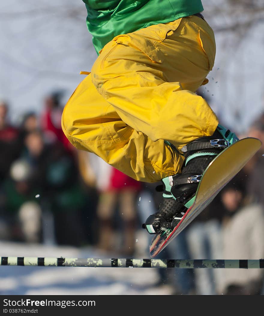 Snowboarder jumping over a beam