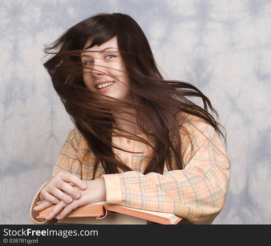 The young girl with books on a light background