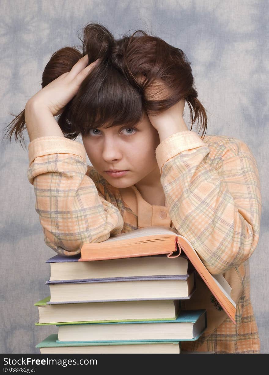 The young girl with books on a light background