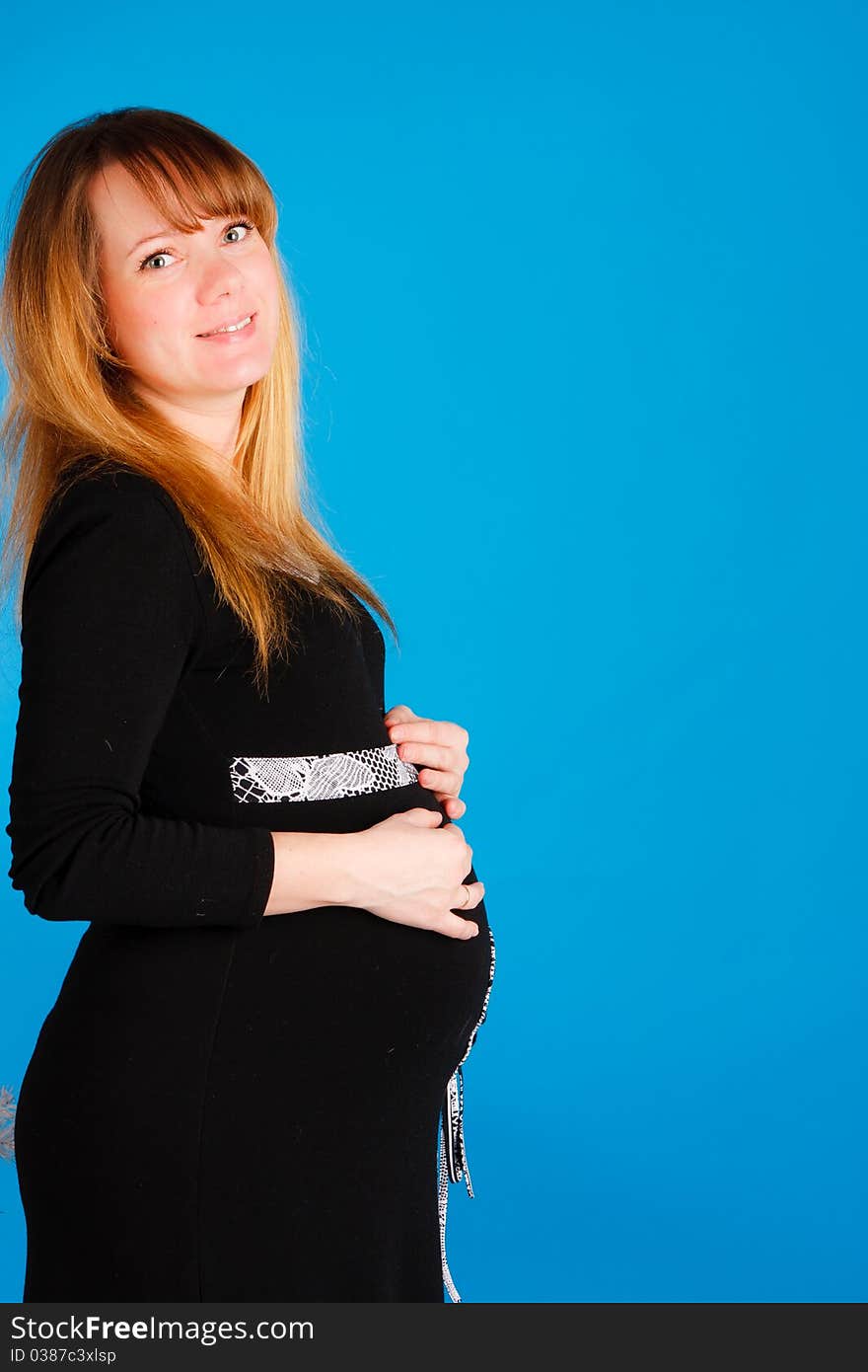 Beautiful pregnant woman staying on blue background