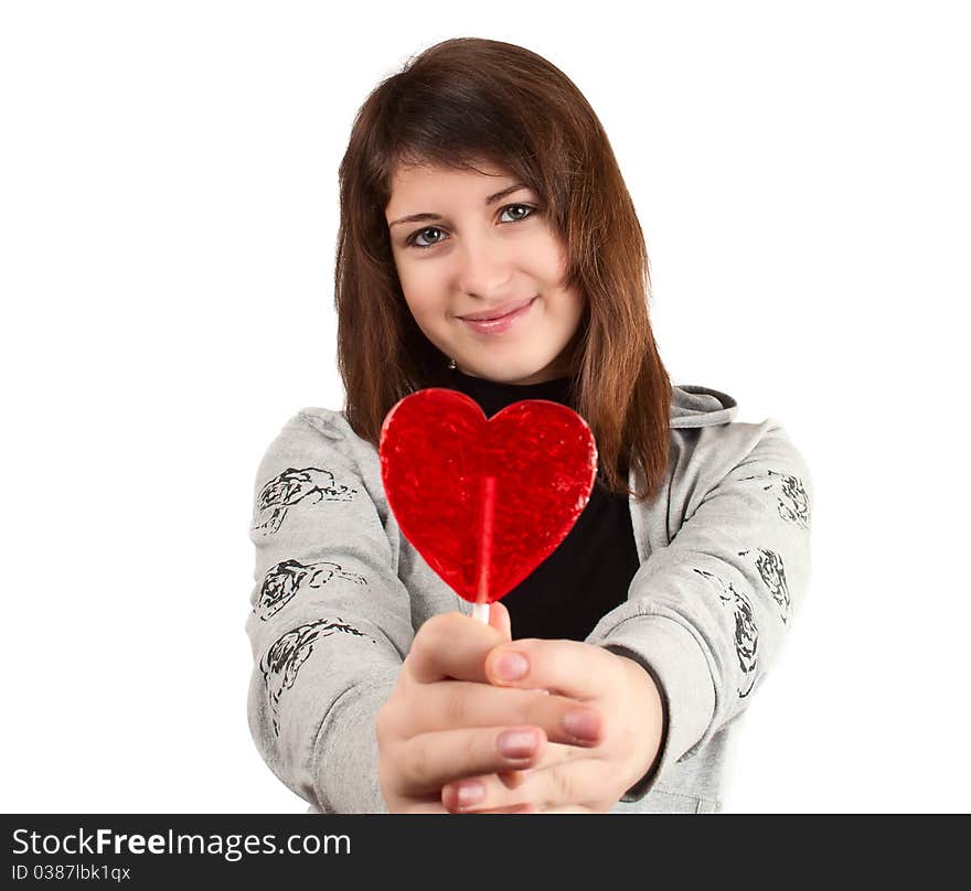 Girl with a heart-shaped candy on a white background